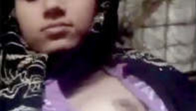 A young Indian woman reveals her petite breasts and intimate area